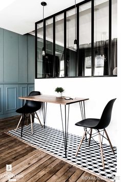 a dining room with black chairs and a wooden table in front of a mirror on the wall