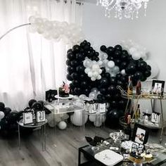 a room filled with black and white balloons