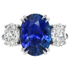 an oval blue sapphire and three diamond ring