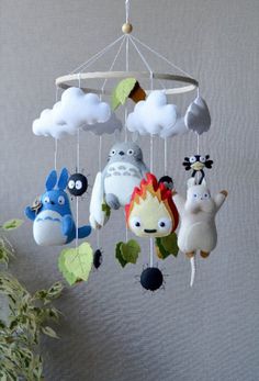 a mobile made to look like cartoon characters hanging from the ceiling with clouds and animals on it