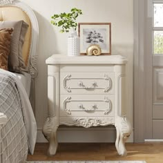 a bedroom with a white dresser next to a bed and a plant on top of it