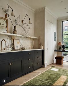 an instagramted photo of a kitchen with blue cabinets and marble counter tops, along with pictures on the wall