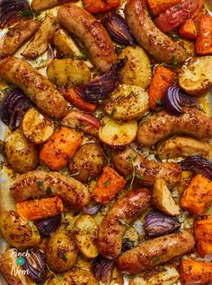 sausages, potatoes and carrots on a baking sheet ready to be cooked in the oven