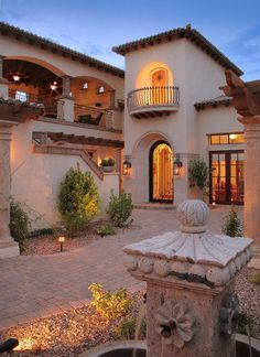 a large house with a fountain in the front yard