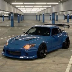 a blue sports car parked in an empty parking garage with no one around it,