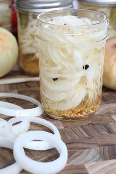 there are onion rings and onions in a jar on the table next to some scissors