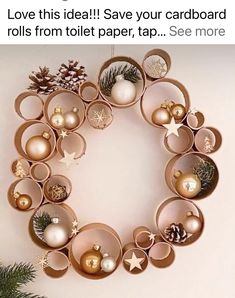 a christmas wreath made out of toilet paper with ornaments on it and pine cones in the middle