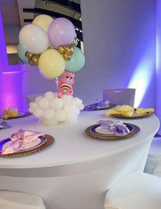 a white table topped with plates and balloons