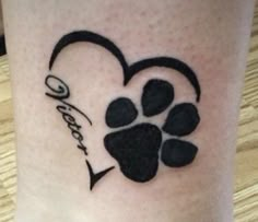 a dog paw and heart tattoo on the leg for someone's love or family