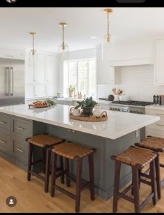 a large kitchen island with stools in front of it and an oven on the other side