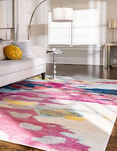 a living room with a white couch and colorful rug