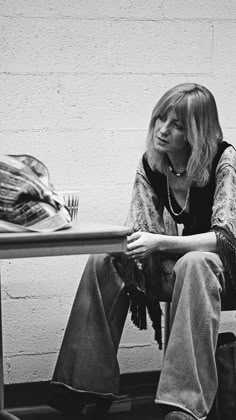 a black and white photo of a woman sitting at a table