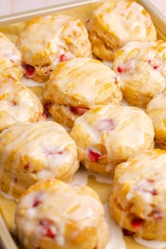 a pan filled with glazed donuts covered in icing and cranberry toppings