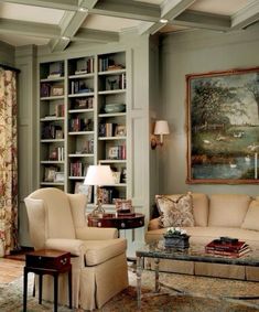 a living room filled with furniture and bookshelves next to a painting on the wall