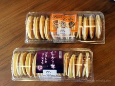 two plastic containers filled with donuts on top of a wooden table