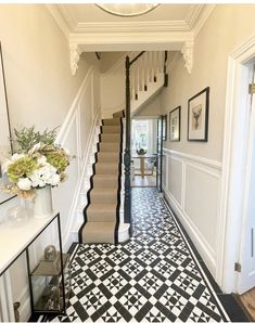 the hallway is decorated with black and white tiles on the floor, along with stairs