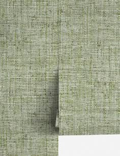 a white piece of paper sitting on top of a green cloth covered in small squares