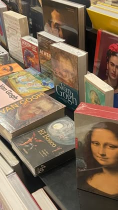 many books are stacked on top of each other in this room with one woman's face painted on the cover