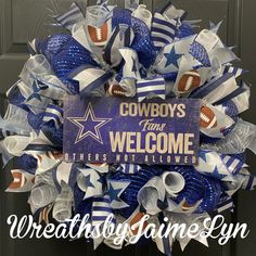 the wreath is decorated with footballs and ribbons for cowboys fans to welcome their team