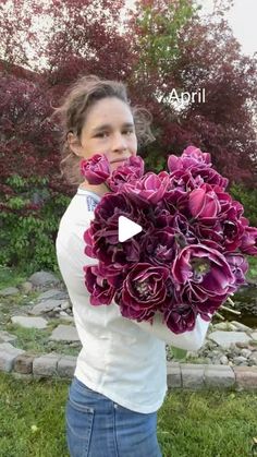 a woman holding a bouquet of purple flowers