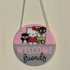 a sign that says welcome friends hanging from a wall with two cats and a bird on it