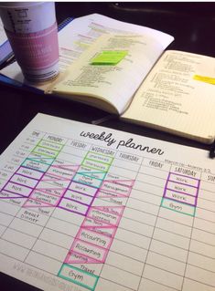 a table with a planner and coffee cup on it