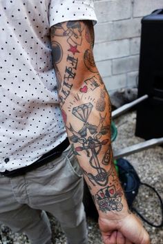 a man holding his arm with tattoos on it