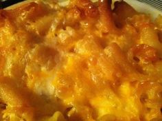 a casserole dish with cheese and meat in it sitting on a plate next to a fork