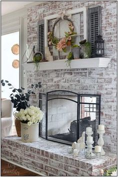 a brick fireplace with flowers and candles on it