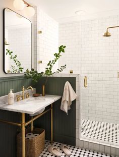 a white tiled bathroom with green and gold accents