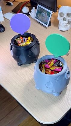 two plastic containers filled with candy sitting on top of a desk