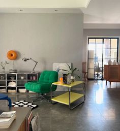 a living room filled with furniture and a green chair next to a yellow coffee table