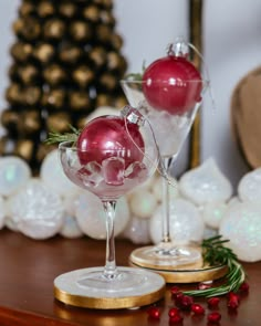 Two clear Christmas ornaments sit in martini glasses filled with ice. The ornaments are filled with a glittery vodka cranberry cocktail Ornament Martini Drink, Ornamentini Cocktail Recipe, Christmas Ornament Drink Recipe, Ornamentini Cocktail, Christmas Cocktail Garnish, Ornament Cocktail Ideas, Ornaments Drinks, Christmas Ornament Cocktails, Christmas Ornament Drinks