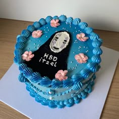 a blue cake decorated with an image of a woman's face and flowers on it