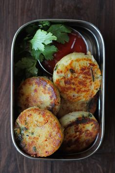 some food in a metal container on a wooden table