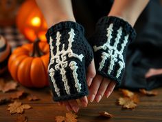 a person wearing black and white crocheted mitts on top of a wooden table