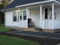 a white house with black shingles on the front porch