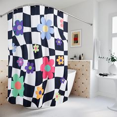 a bathroom with a checkered shower curtain that has colorful flowers on it and is next to a bathtub