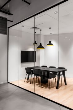 an empty conference room with glass walls and black chairs