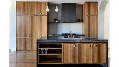 a kitchen with wooden cabinets and black counter tops, along with an island in the middle