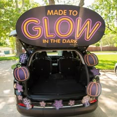 the back end of a car with an advertisement on it's trunk that says made to glow in the dark