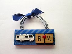 a keychain with a rv on it and a blue ribbon hanging from the front