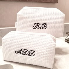 two white towels with the word monogrammed on them sitting on a bathroom counter