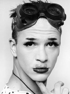 a young man with goggles on his head is posing for a photo in front of a white background