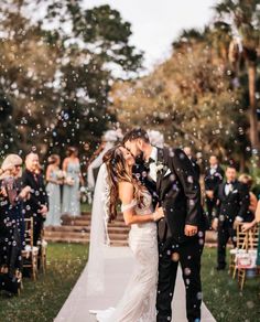 a newly married couple kissing in front of bubbles