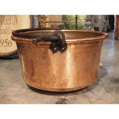 an old fashioned copper pot is sitting on the floor