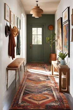 a hallway with green door and rugs on the floor