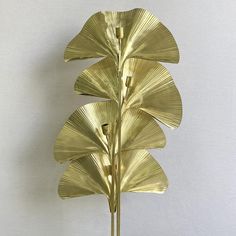 a gold leaf sculpture is shown against a white wall