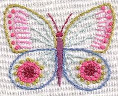 a close up of a butterfly on a piece of white fabric with pink and yellow accents