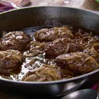 meatballs and onions cooking in a skillet